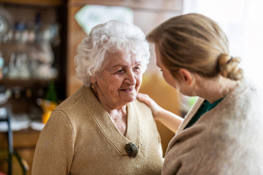 Senior woman with dementia talking with caregiver