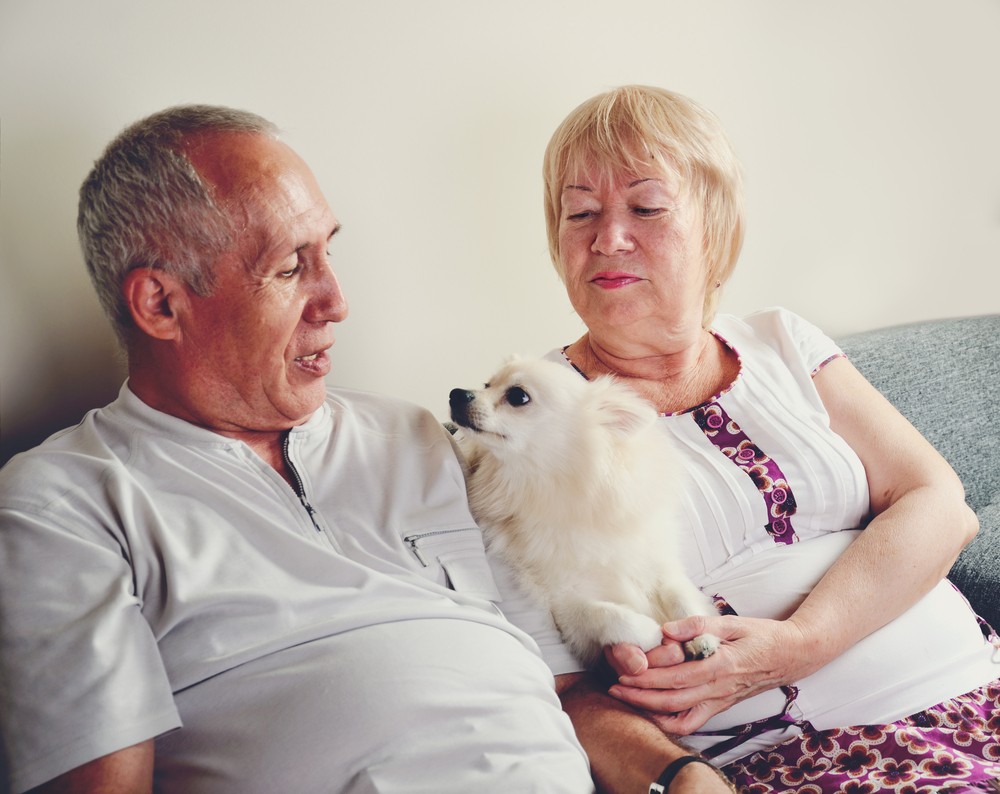 Senior couple sitting with Pomeranian dog