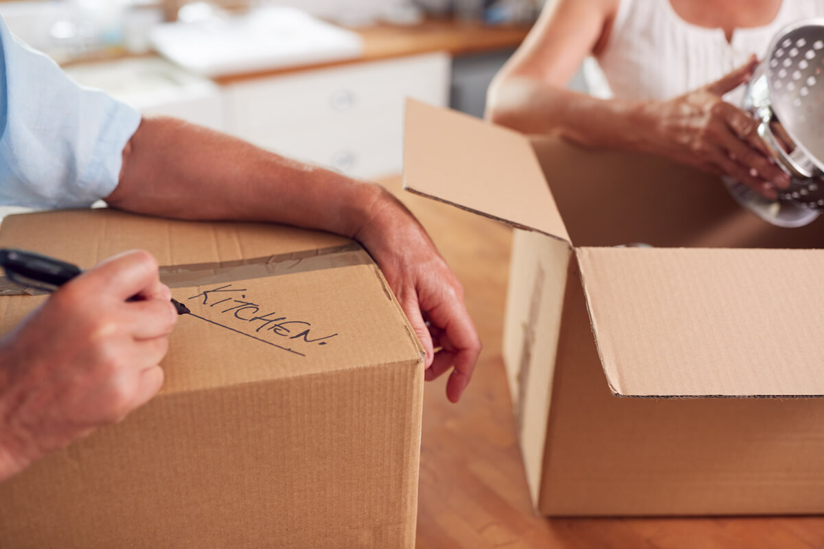 Close Up Of Senior Couple Downsizing In Retirement Boxes Ready For Move Into New Home-Downsizing tips
