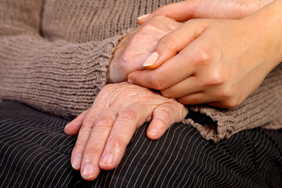 Nurse holding elderly woman's hand-Dementia care