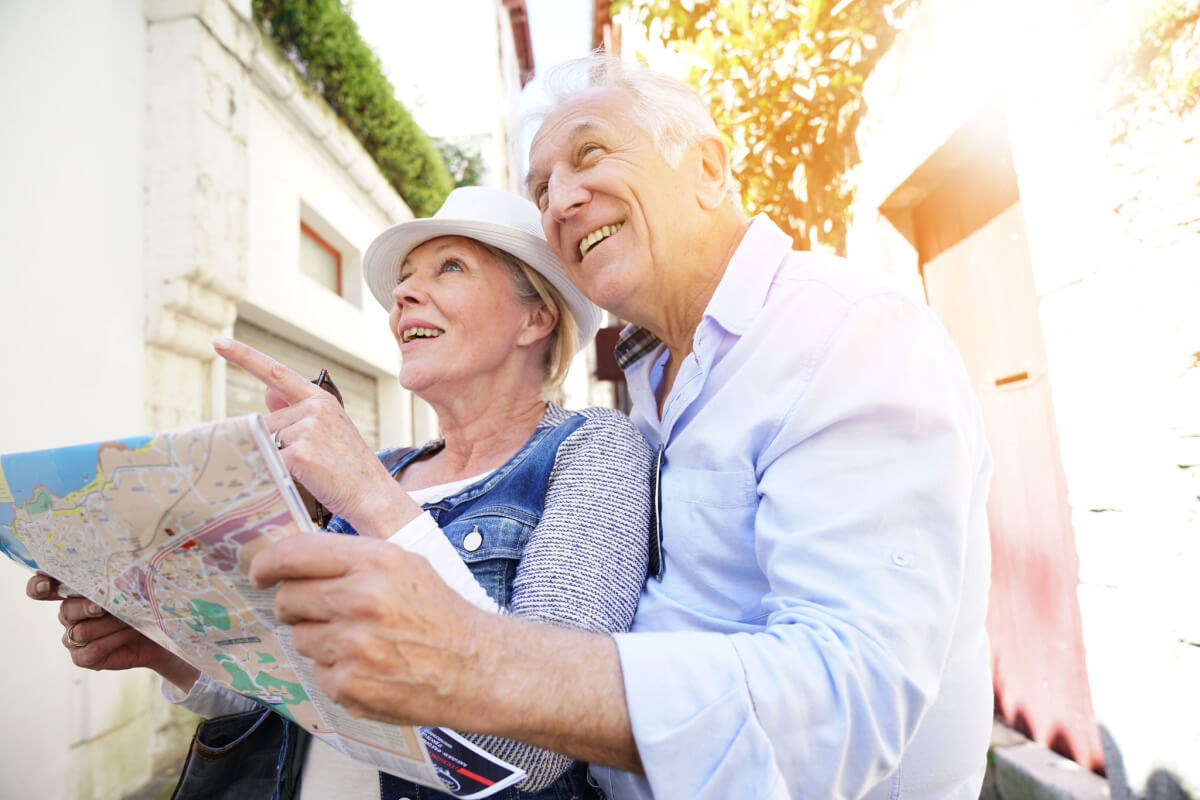 Older couple holding map, smiling-Discover Senior Living in Franklin, Indiana